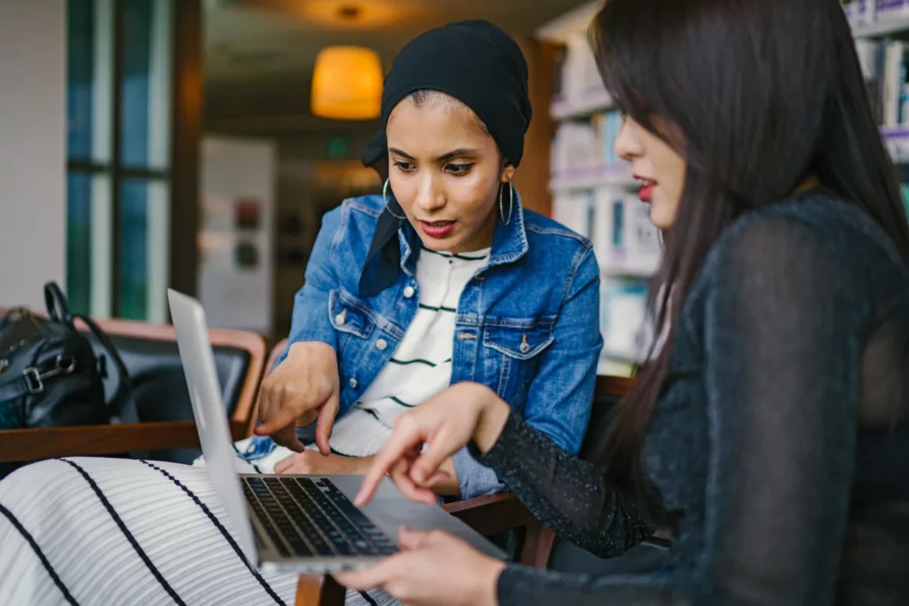 Two women sharing a laptop screen